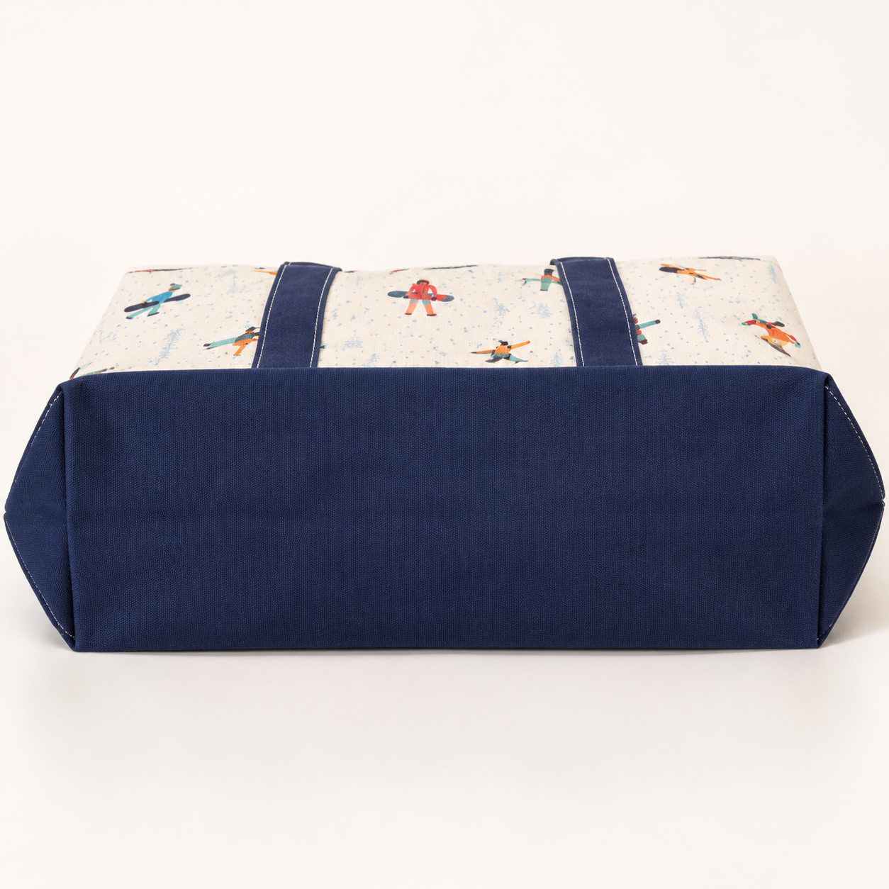 Reinforced navy bottom gusset on white snowboard canvas tote bag