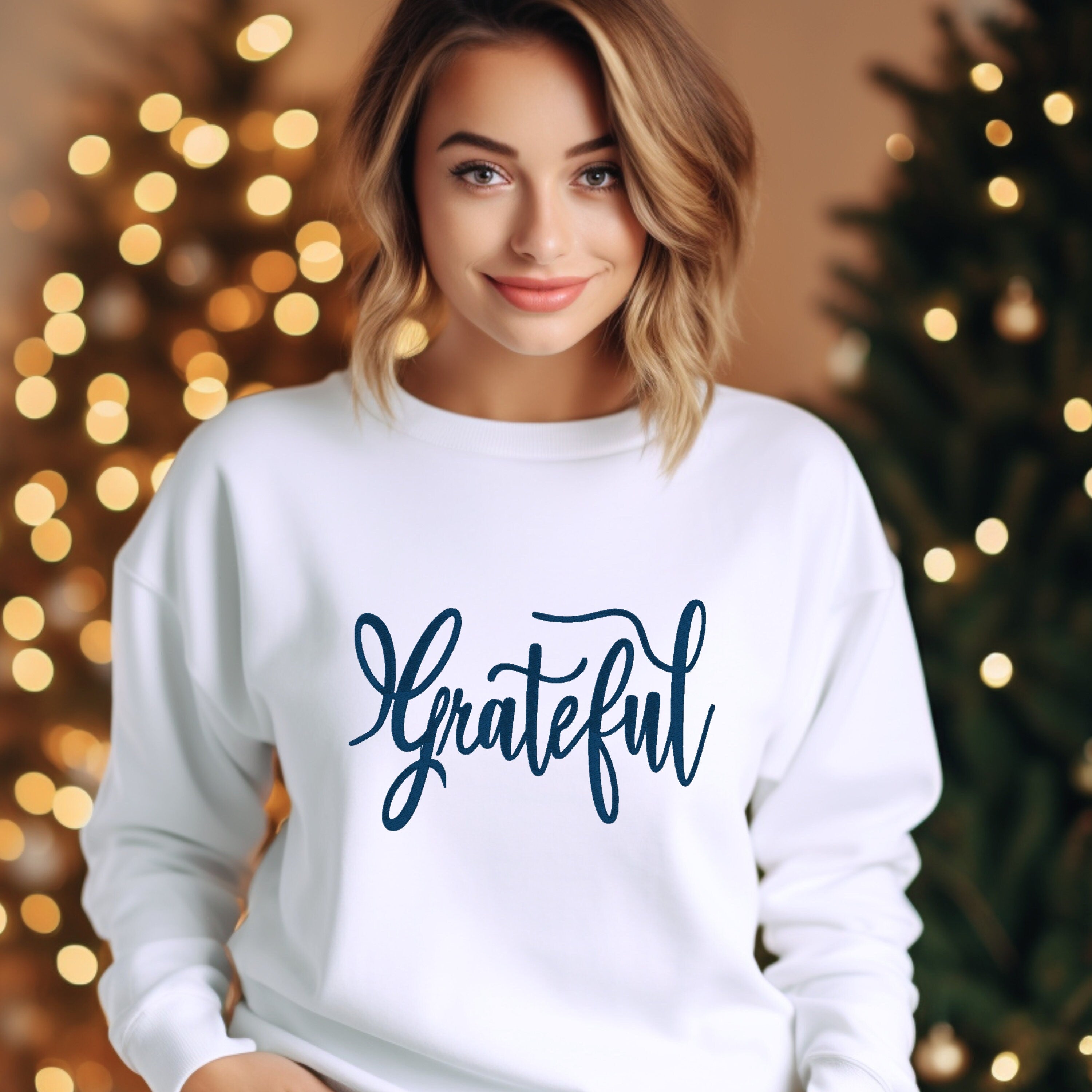 White sweater with the word &quot;Grateful&quot; embroidered on the front.