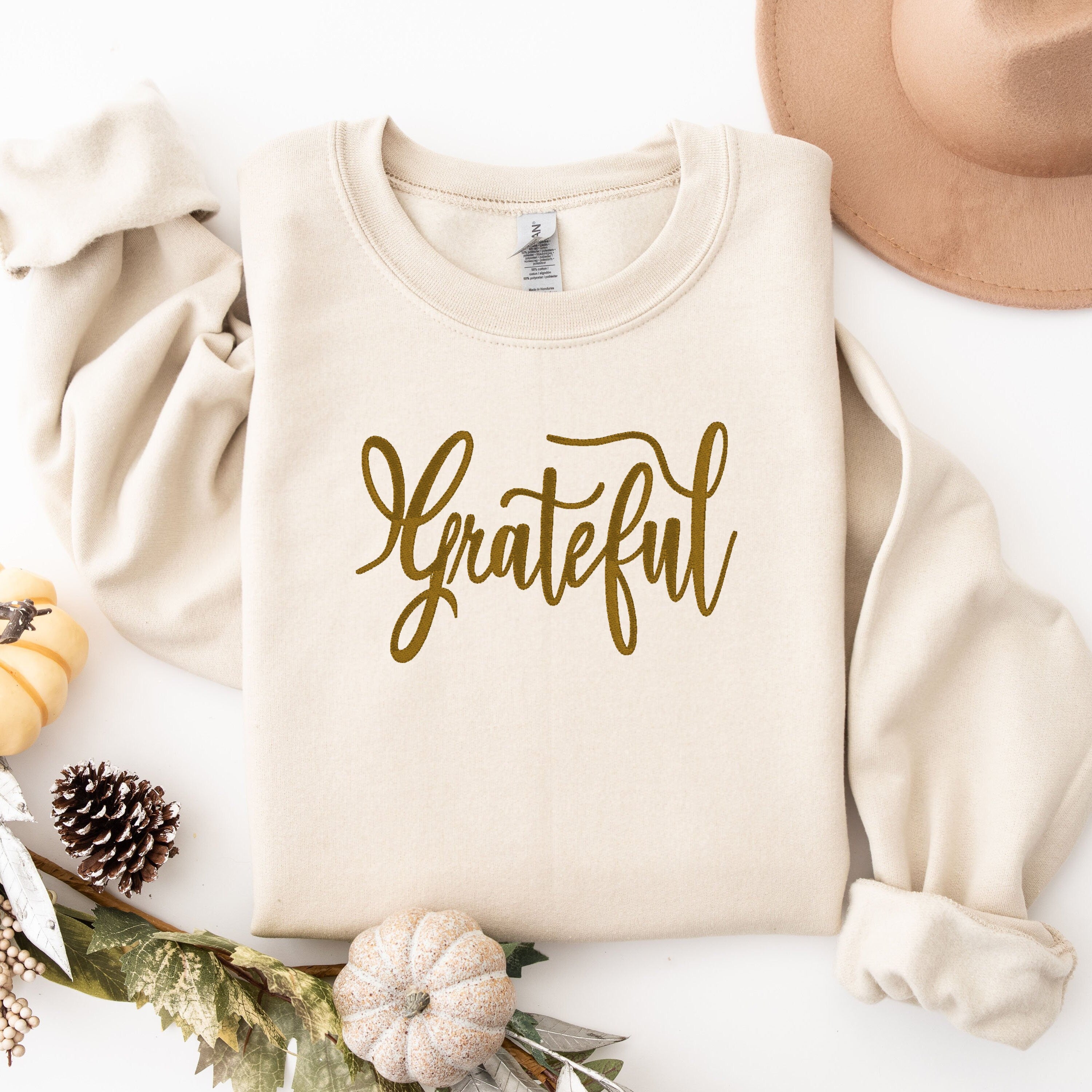 Stone sweater with the word &quot;Grateful&quot; embroidered&quot; on the front.