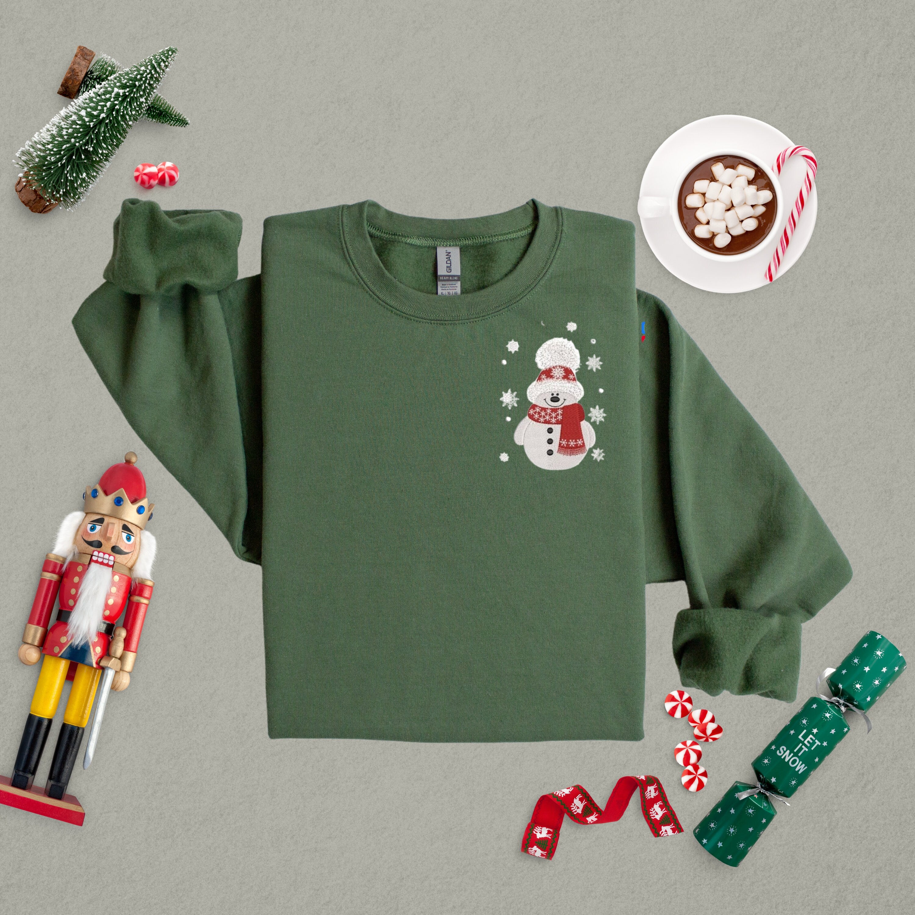 Military green sweatshirt with snowman embroidered on the front.