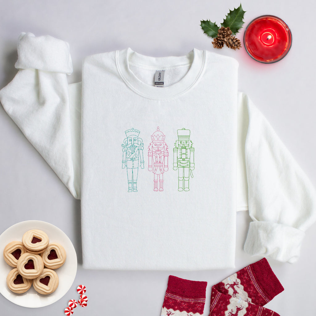 Embroidered white sweater with three nutcracker men on front. Christmas Sweater.
