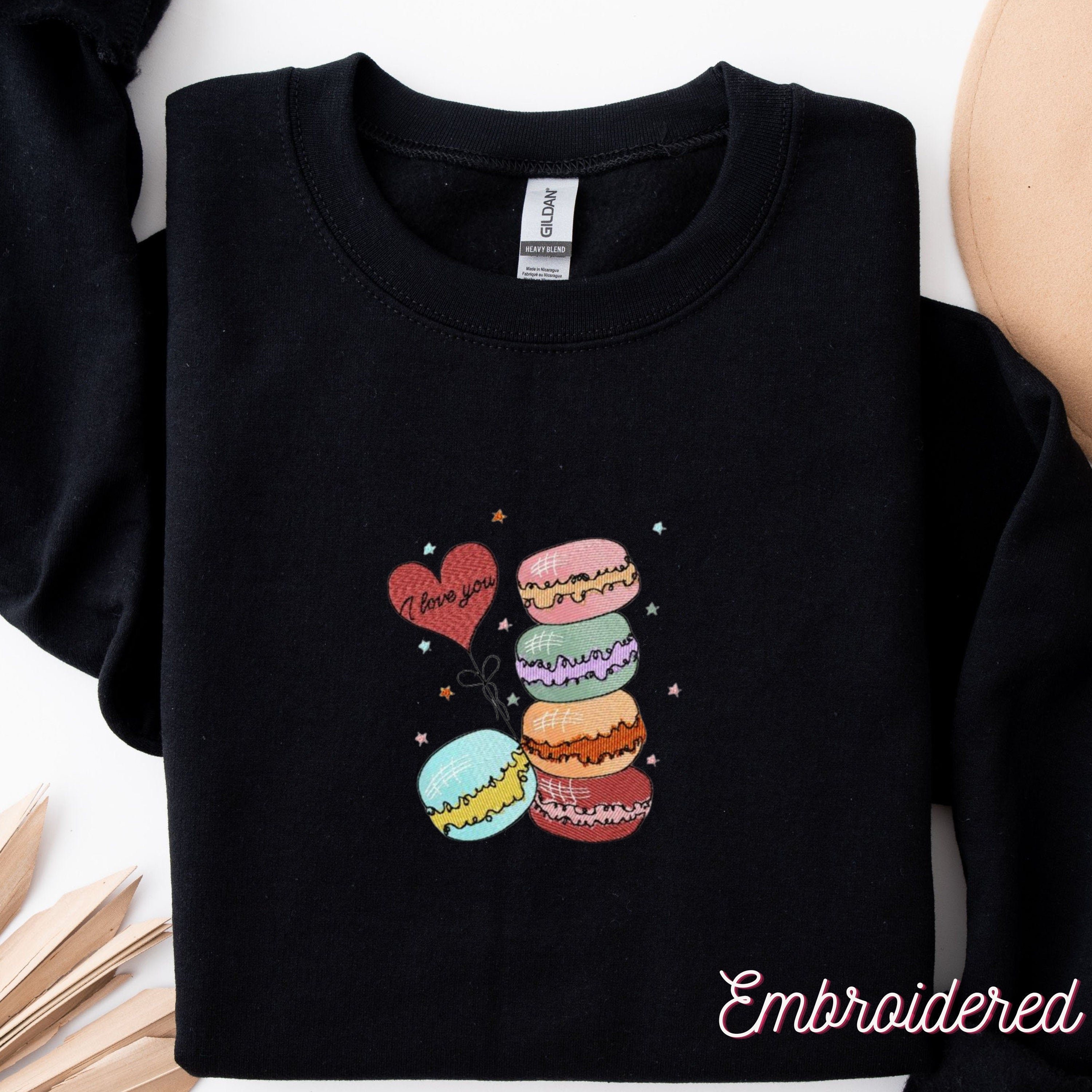 Valentine Macaroons embroidered onto a black fleece lined crewneck sweater.