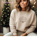 Stone colored cozy fleece lined sweater embroidered with the "North Pole Cookie Co" design.