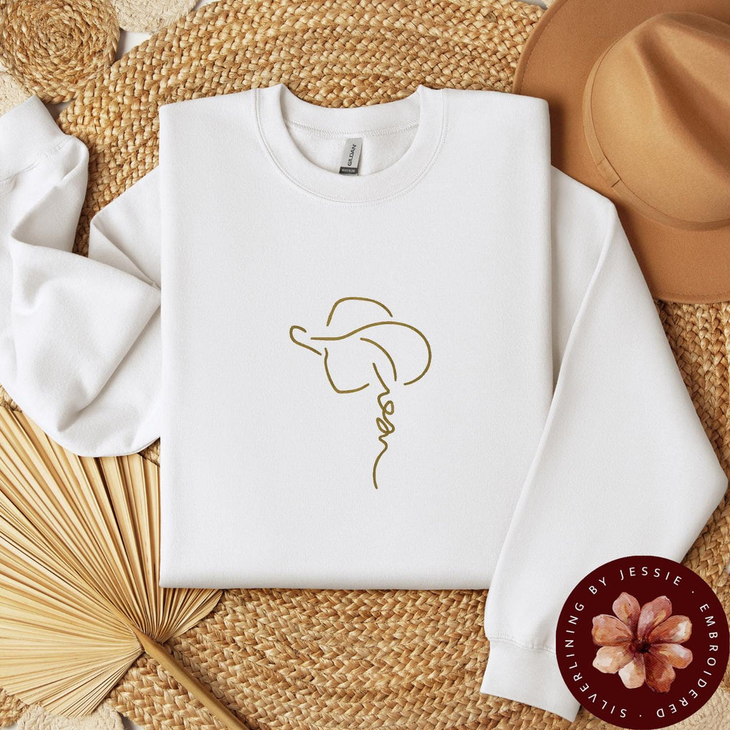 Tan Cowgirl with Hat outline stitched onto a white cozy crewneck fleece lined sweatshirt